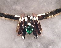 Tri-color gold slide with .70ct oval emerald and .15ct diamond