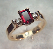 8 x 6mm emerald cut garnet ring with diamonds in bridged mounting